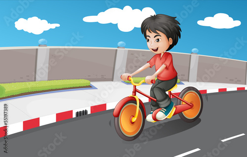 A boy riding in his bike with orange wheels