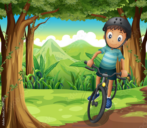 A boy biking in the middle of the forest