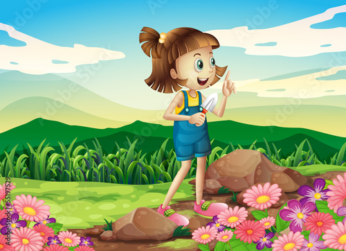 A girl holding a shovel at the flower garden