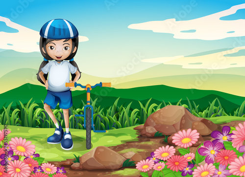 A young girl with a bike standing near the rocky area