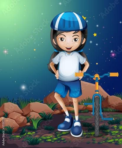 A female biker standing near the rocks