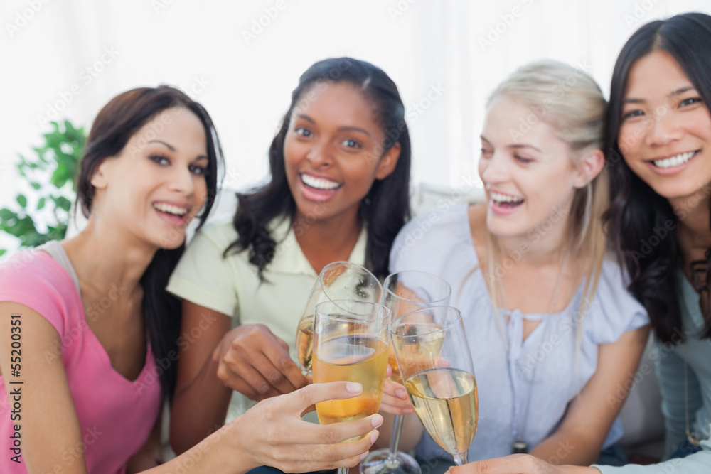 Friends toasting with white wine and smiling at camera Friends toasting with white wine and smiling at camera