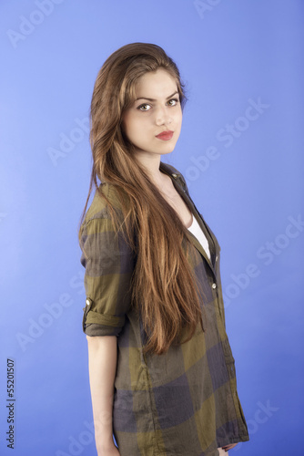 studio portrait of beautiful woman with long hair on blue backgr