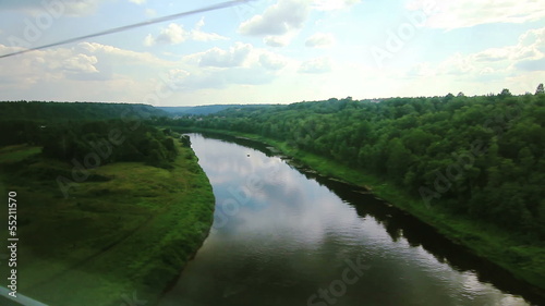 High-speed train goes on the bridge over the river (POV) photo