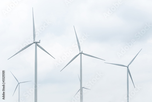 wind turbine in wind farm against cloudy sky