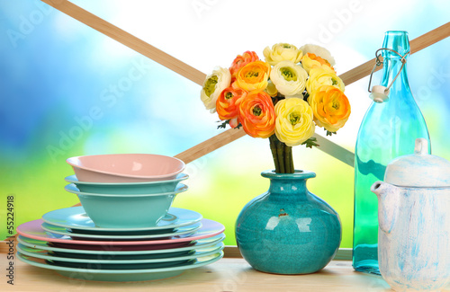 Beautiful dishes on wooden cabinet on natural background