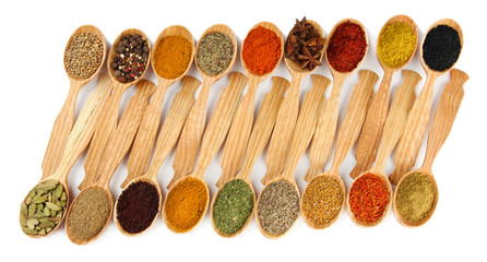 Fototapete Gewürze Assortment of spices in wooden spoons, isolated on white  © Africa Studio