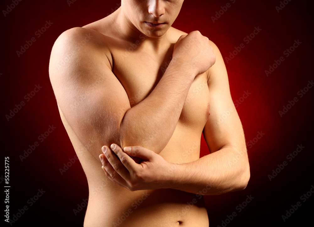 Young man with elbow pain, on red background Young man with elbow pain, on red background