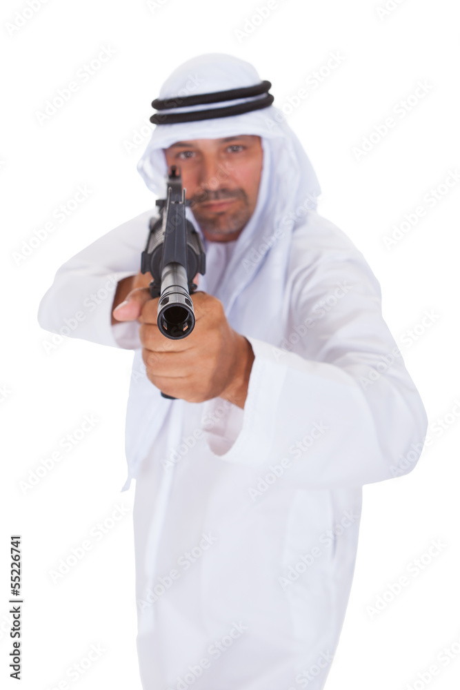 Portrait of man aiming rifle against white background