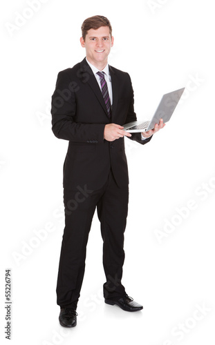 Happy businessman holding laptop