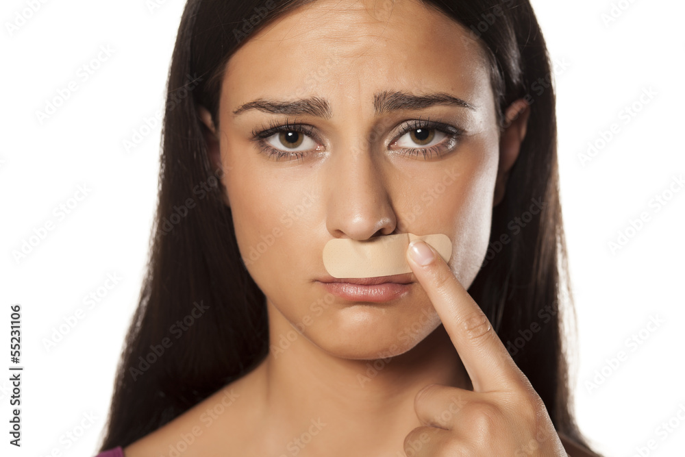 patch under her nose because of bad waxing her mustache Stock Photo