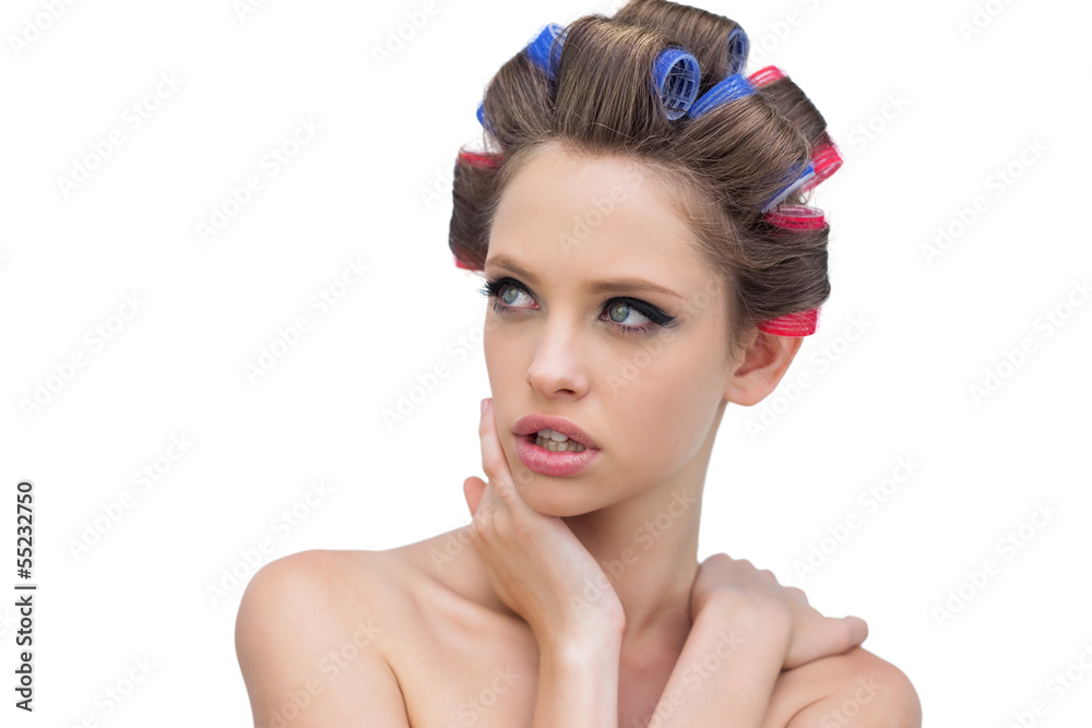 Naklejka premium Seductive lady in hair rollers posing and looking away