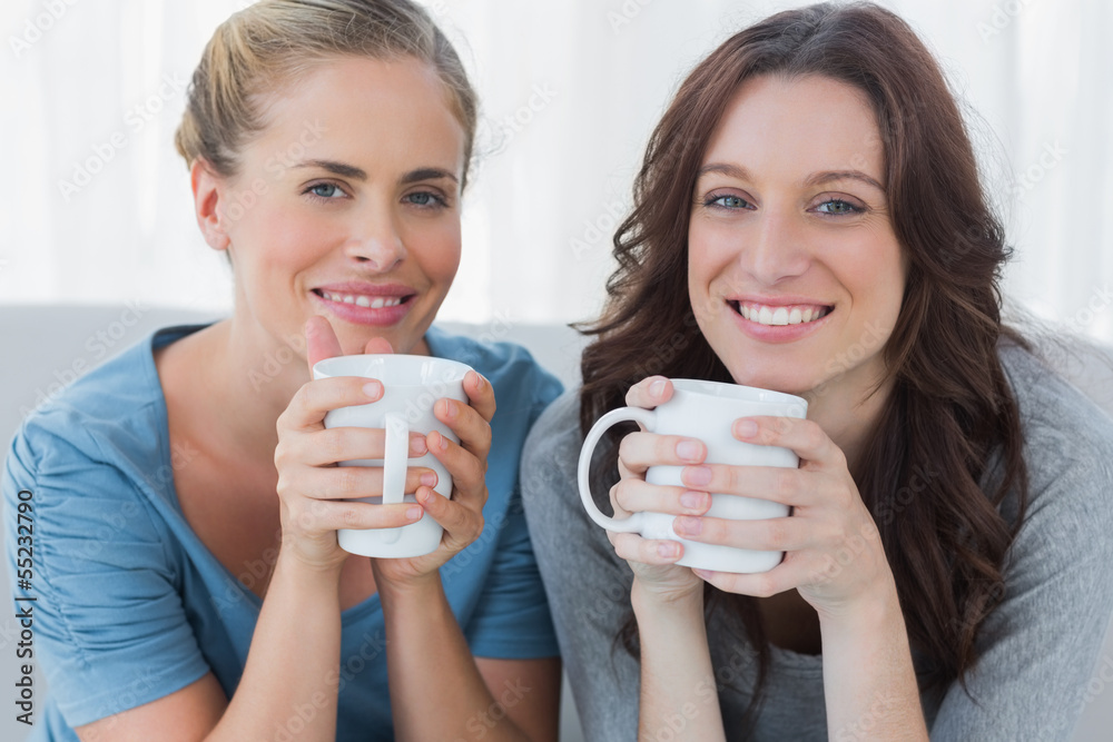 Friends having coffee and looking at camera Friends having coffee and looking at camera