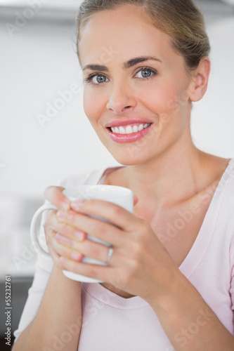 Fototapeta Naklejka Na Ścianę i Meble -  Radiant blonde woman drinking coffee