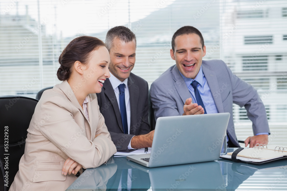 Cheerful colleagues working together on their laptop Cheerful colleagues working together on their laptop