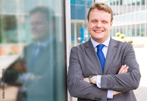 Smiling businessman standing outside a building