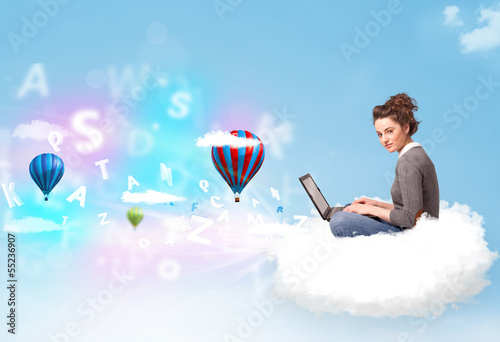 Young woman sitting in cloud with laptop photo