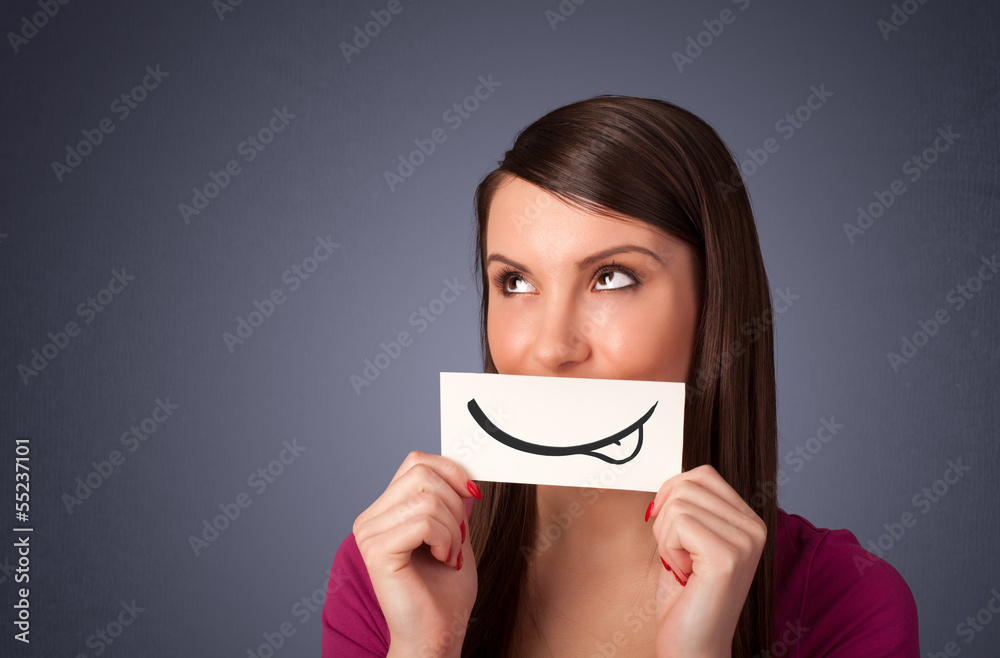 Pretty young girl holding white card with smile drawing Pretty young girl holding white card with smile drawing