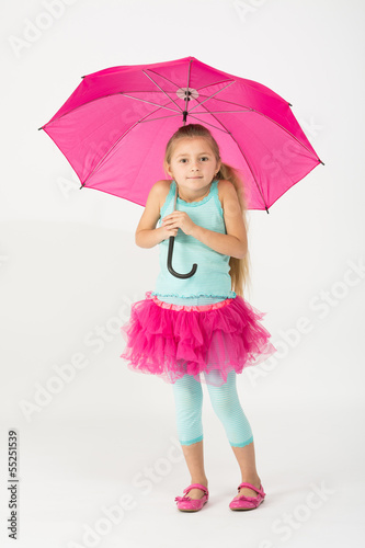 A girl in a pink skirt is chilly with a pink umbrella
