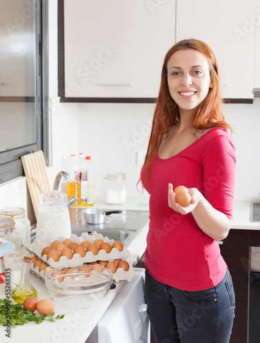  woman in red making omelet in home