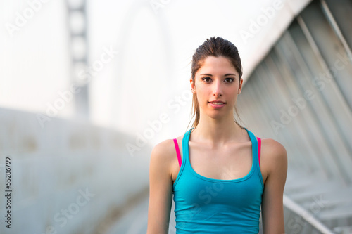 Beautiful young woman in blu singlet relaxing after running outd