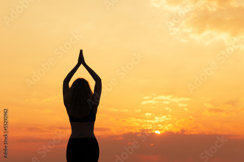 girl does yoga at sunset