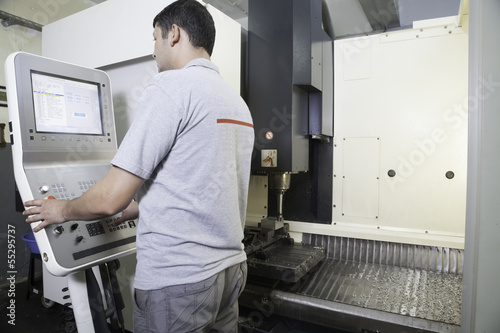 Operator running a CNC lathe machine