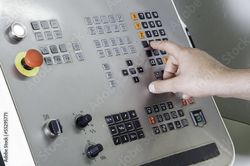 Operator controlling CNC lathe machine