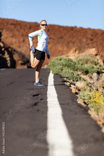 Runner stretching on road
