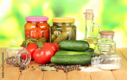 Tasty green cucumbers and red tomatoes in basket,
