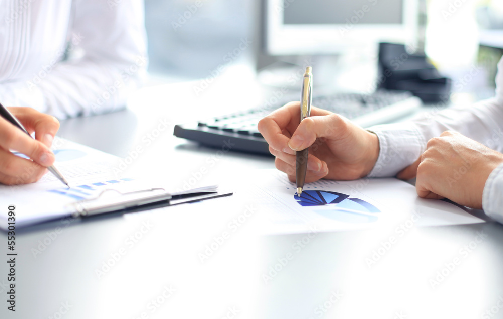 Unrecognizable business person analyzing graphs Unrecognizable business person analyzing graphs