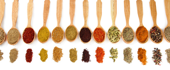 Fototapete Gewürze Assortment of spices in wooden spoons, isolated on white  © Africa Studio