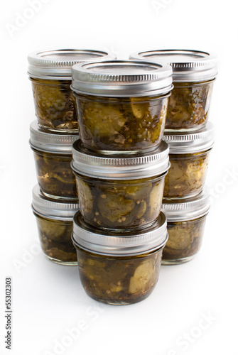 Nine jars of pickes stacked on a white isolated background