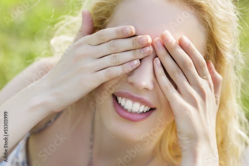 Playful woman covering her eyes with her hands. Hide-and-seek