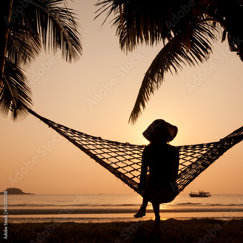 woman in hammock enjoying sunset on the beach photo