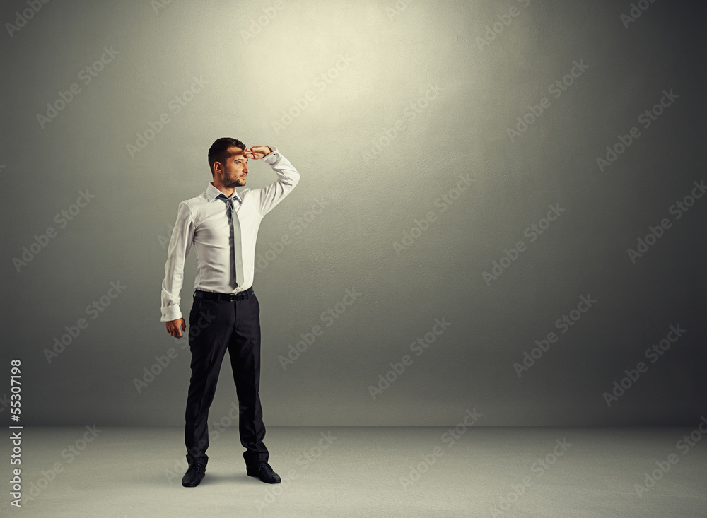 serious man standing in dark room serious man standing in dark room