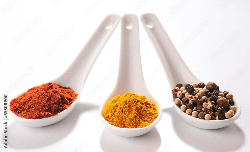 collection of hot spices in small spoons white porcelan
