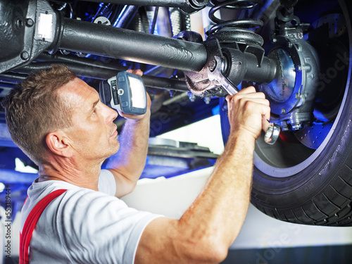 Mechanic in a garage checks the car