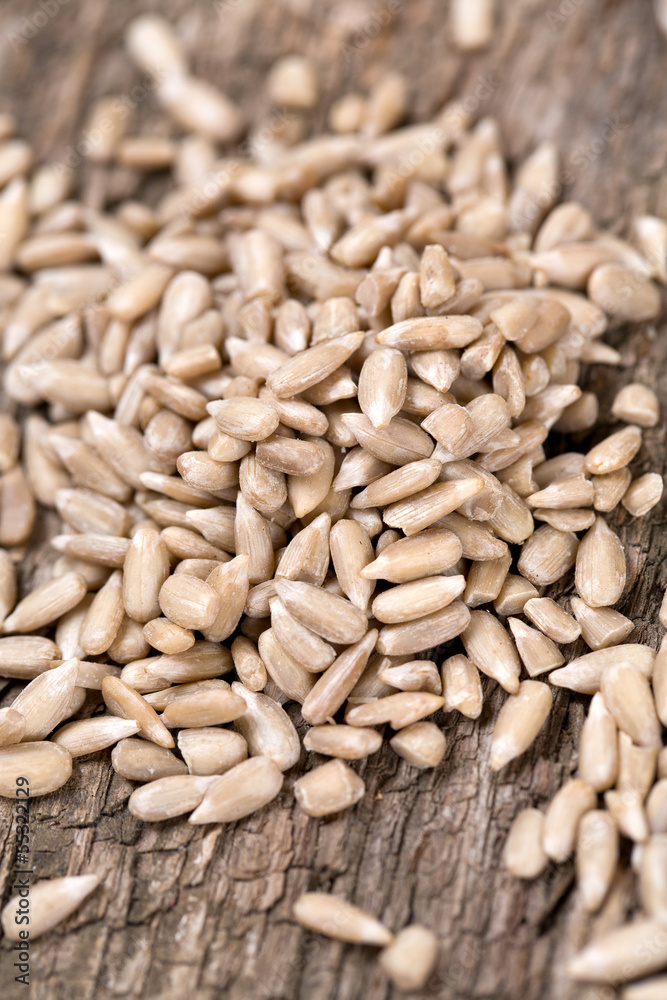 peeled sunflower seeds on wooden surface peeled sunflower seeds on wooden surface