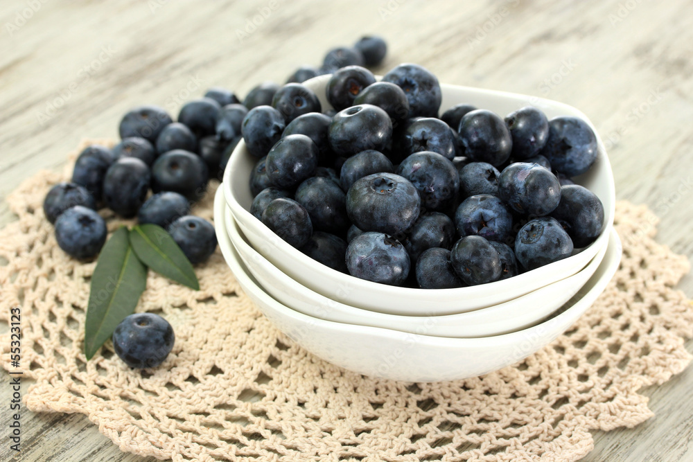 Blueberries in plates on napkin on wooden background Blueberries in plates on napkin on wooden background
