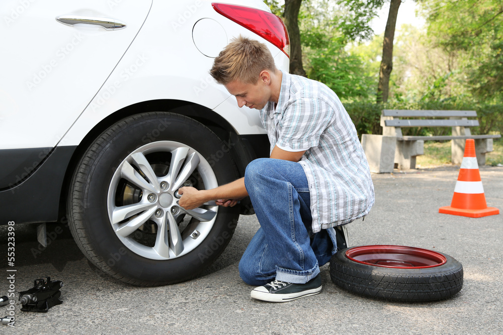 Man driver having trouble at road changing wheel Man driver having trouble at road changing wheel