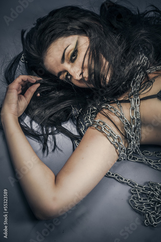 Bondage, beautiful brunette young with silver chains