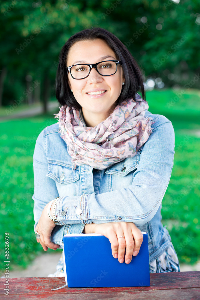 Obraz premium Beautiful young woman with book in park