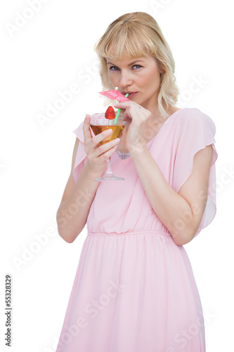 Pretty blond woman drinking cocktail and looking at camera