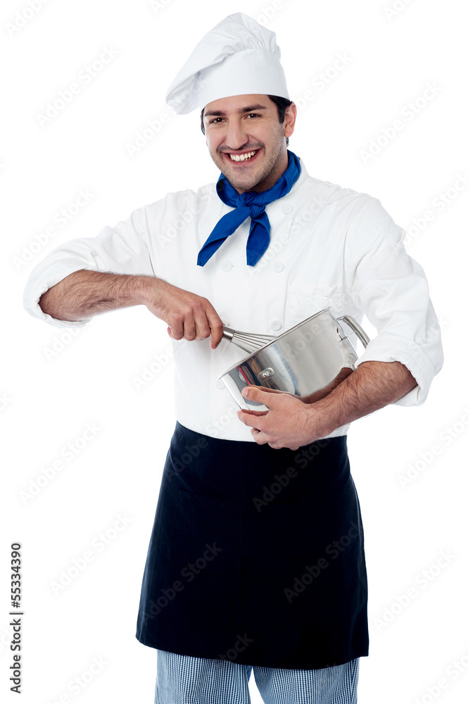 Experienced male chef using egg beater Experienced male chef using egg beater