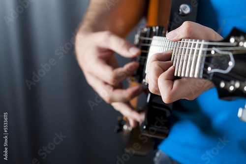 close up shot of strings and guitarist hands playing guitar © erika8213
