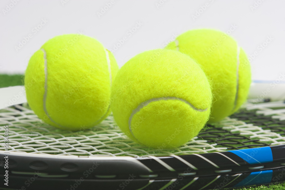 Tennis concept: extreme closeup, tennis racket with balls lies o