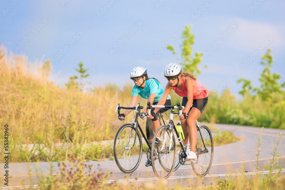 Training cycle  of the two female caucasian sportswomen riding s