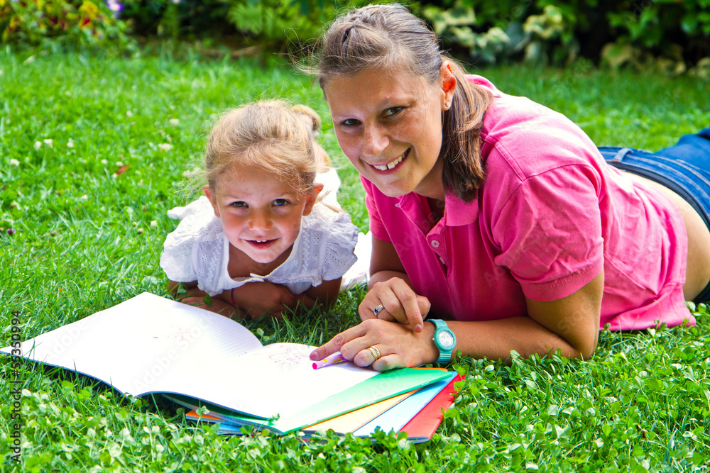 happy mother drawing a book with baby girl in garden happy mother drawing a book with baby girl in garden