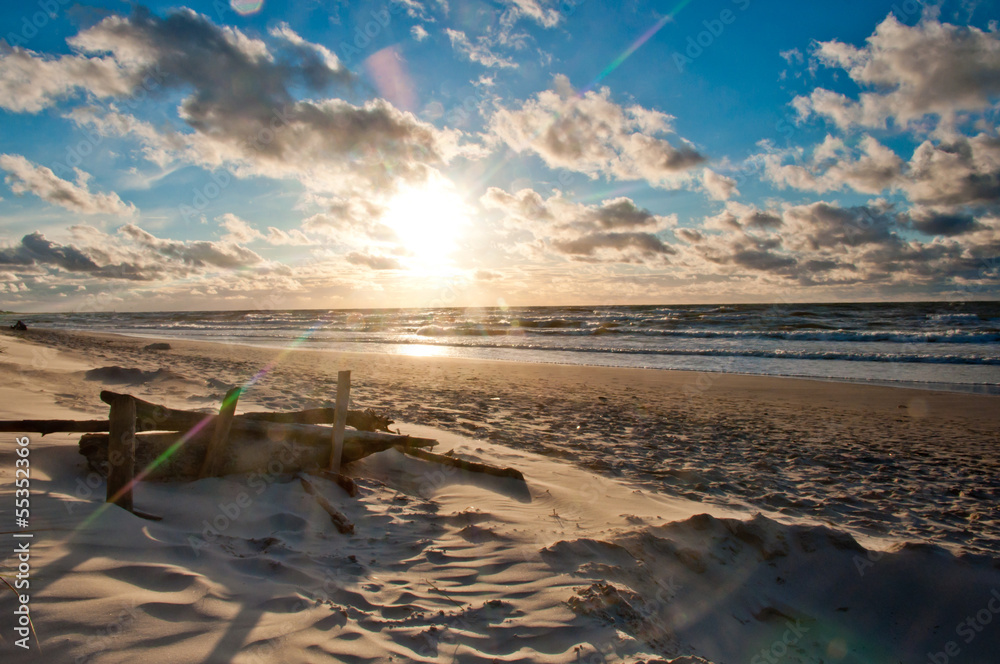 sunrise on beach with branch in foreground sunrise on beach with branch in foreground